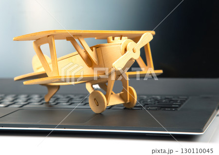Model of a wooden plane on the background of a laptop Model of a wooden plane on the background of a laptop 130110045