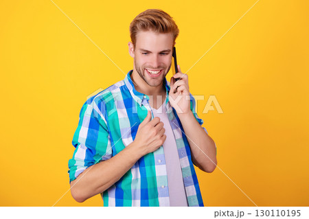 Calling back. Man talk on smartphone. Phone call. Mobile communication. Nice conversation. Man speak on smartphone isolated on yellow. Millennial man has phone conversation 130110195