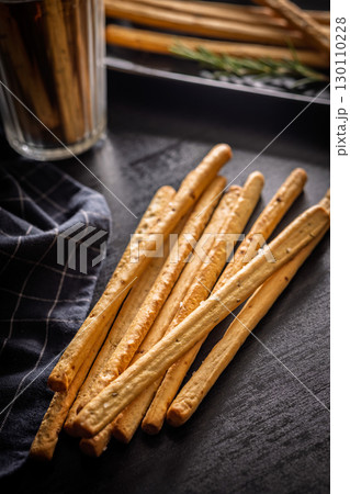 Crispy grissini breadsticks on black table. Crispy grissini breadsticks on black table. 130110228