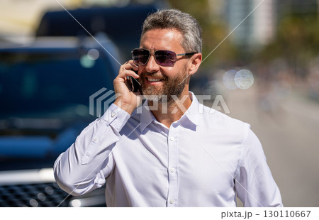 Business man talking on phone outdoor. Businessman using phone. Business call. Man phone conversation. Mature business man with phone. Business communication. Negotiation online. Customer service Business man talking on phone outdoor. Businessman using phone. Business call. Man phone conversation. Mature business man with phone. Business communication. Negotiation online. Customer service 130110667