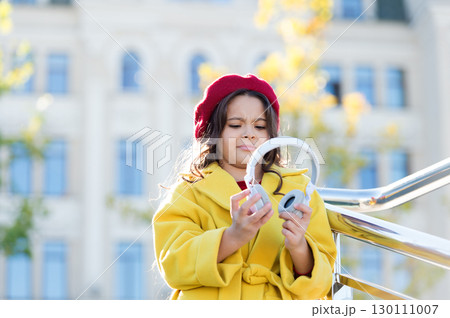 Little girl listening music enjoy favorite song excellent sound. Good vibes only. Awesome sound. Girl kid with headphones urban background. Stereo sound. Child girl autumn outfit enjoying music 130111007