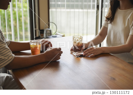 テーブルで真剣に話し合う男女の姿 130111172