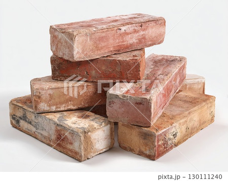 Worn red bricks stacked on clean background. Rustic construction pieces with weathered look, great for historic home decor. Worn red bricks stacked on clean background. Rustic construction pieces with weathered look, great for historic home decor. 130111240