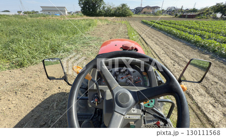 トラクター運転席から撮影、草の畑を耕す 130111568