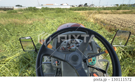 トラクター運転席から撮影、草の畑を耕す 130111572