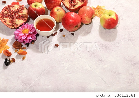 Creative composition for the Jewish holiday Ro Hashanah with a place for congratulations. Layout with traditional symbols of the Jewish New Year, template with honey, apples, pomegranate and flowers Creative composition for the Jewish holiday Ro Hashanah with a place for congratulations. Layout with traditional symbols of the Jewish New Year, template with honey, apples, pomegranate and flowers 130112361