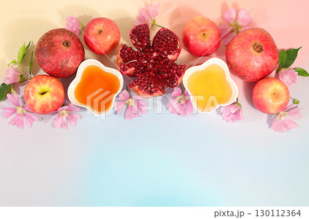 Autumn banner with honey, apples, pomegranates, flowers, dried fruits for holiday greeting, composition for Jewish holiday Rosh Hashanah with traditional symbols, creative layout for design, template 130112364