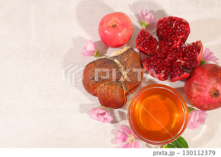 Creative composition for the Jewish holiday Ro Hashanah with a place for congratulations. Layout with traditional symbols of the Jewish New Year, template with honey, apples, pomegranate and flowers Creative composition for the Jewish holiday Ro Hashanah with a place for congratulations. Layout with traditional symbols of the Jewish New Year, template with honey, apples, pomegranate and flowers 130112379