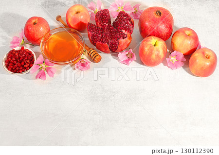 Autumn banner with honey, apples, pomegranates, flowers, dried fruits for holiday greeting, composition for Jewish holiday Rosh Hashanah with traditional symbols, creative layout for design, template Autumn banner with honey, apples, pomegranates, flowers, dried fruits for holiday greeting, composition for Jewish holiday Rosh Hashanah with traditional symbols, creative layout for design, template 130112390