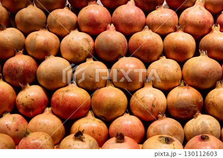 Vibrant and Colorful Pomegranates Beautifully Stacked at the Local Farmers Market 130112603