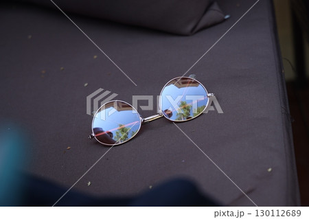 Sunglasses Placed on a Couch That Beautifully Reflects Nature and Its Surroundings 130112689