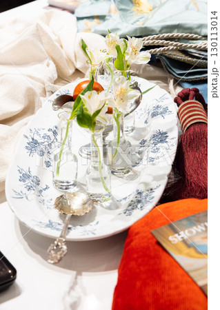An Elegant Dining Table Setting that Features Beautiful Floral Accents and Vintage Tableware 130113014