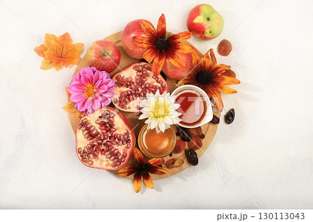 Top view of jewish holiday rosh hashan,honey,apples,pomegranates,flowers,dried fruits on stone table top,space for text,with copy space,hello autumn and thanksgiving day concept,selective focus 130113043