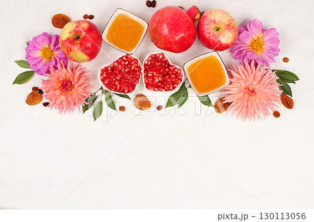 Jewish holiday Rosh Hashanah concept with apples, honey, pomegranate and dried apricots on light background, top view with place for your text, Jewish New Year and Thanksgiving, selective focus 130113056