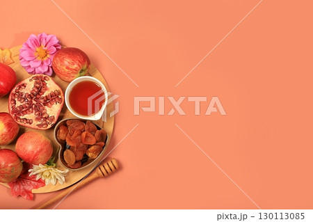 Autumn banner with honey, apples, pomegranates, flowers, dried fruits on a warm orange background, composition for the Jewish holiday Rosh Hashan, space for text, Hello autumn and thanksgiving day 130113085