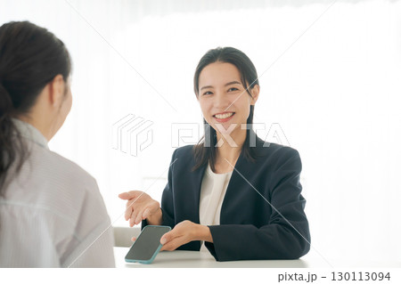 商品の説明をする女性 130113094