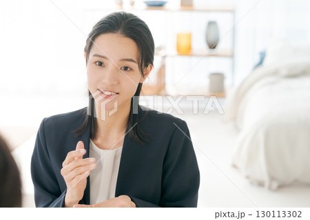 商品の説明をする女性 130113302