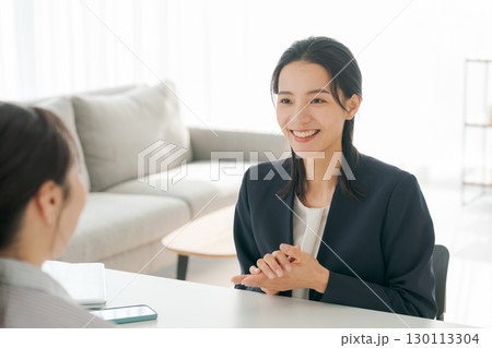 商品の説明をする女性 130113304