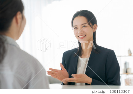 商品の説明をする女性 130113307