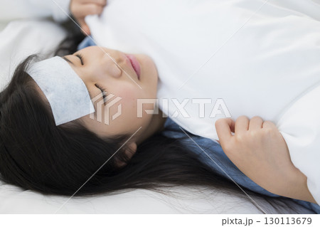 熱を出した小学生の女の子とお母さん 130113679