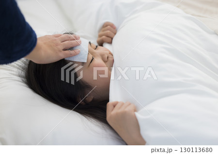 熱を出した小学生の女の子とお母さん 130113680