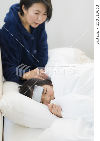 熱を出した小学生の女の子とお母さん 130113683