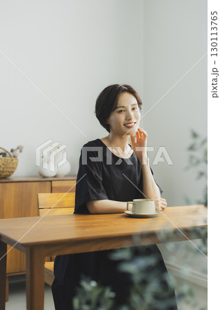カフェでくつろぐ若い女性  130113765