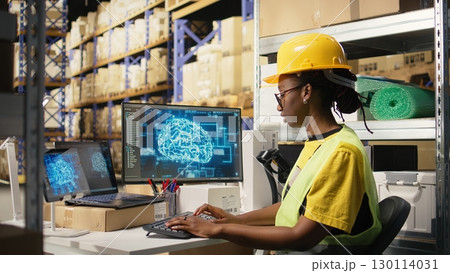 African american woman uses AI deep learning software for e-commerce automation, working in distribution hub with neural networks brain managing tracking software. Data science. Camera A. 130114031