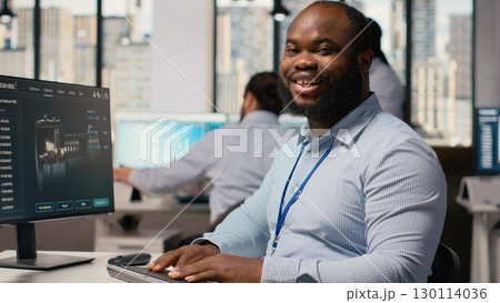 Engineer improves wind turbine carbon footprint by optimizing blade aerodynamics. RD department worker testing advanced materials of eco friendly windmill in office, camera B 130114036