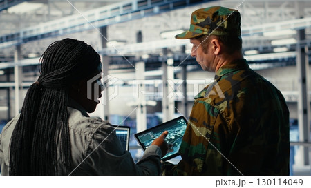 Military data center engineers using AI machine learning radar software to watch for enemy threats. Army technicians in data center use artificial intelligence on devices to detect dangers, camera B Military data center engineers using AI machine learning radar software to watch for enemy threats. Army technicians in data center use artificial intelligence on devices to detect dangers, camera B 130114049