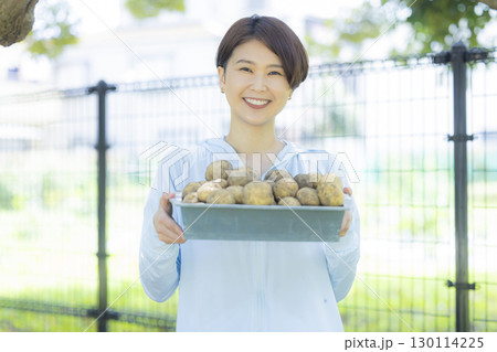 収穫したジャガイモを持つ女性 収穫したジャガイモを持つ女性 130114225