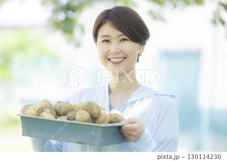 収穫したジャガイモを持つ女性 収穫したジャガイモを持つ女性 130114230