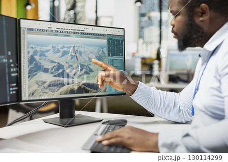 Close up of engineer analyzing advanced wind turbine models to improve efficiency and environmental performance. Designer creates innovative VAWT turbine in CAD software with higher clean energy yield Close up of engineer analyzing advanced wind turbine models to improve efficiency and environmental performance. Designer creates innovative VAWT turbine in CAD software with higher clean energy yield 130114299