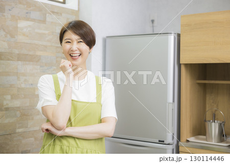 冷蔵庫を開けるエプロン姿の女性 130114446