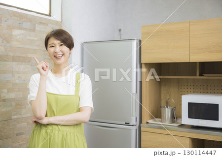 冷蔵庫を開けるエプロン姿の女性 130114447