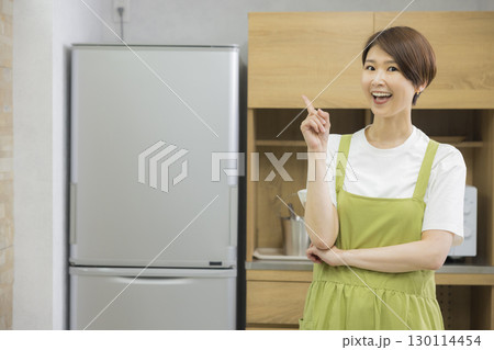 冷蔵庫を開けるエプロン姿の女性 冷蔵庫を開けるエプロン姿の女性 130114454