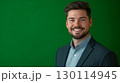 A friendly face with an engaging smile dressed in business casual attire framed by a green background 130114945