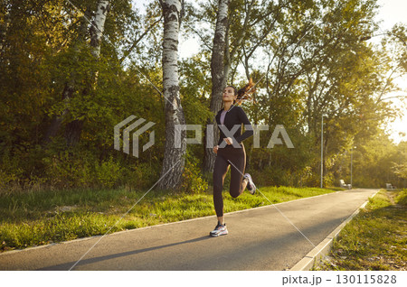 Female young runner jogging alone in city park. Healthy sporty fitness woman running outdoors. 130115828