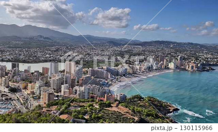 Stunning Aerial View of a Coastal City Showcasing Vibrant Waters and Scenic Mountains Nearby Stunning Aerial View of a Coastal City Showcasing Vibrant Waters and Scenic Mountains Nearby 130115966
