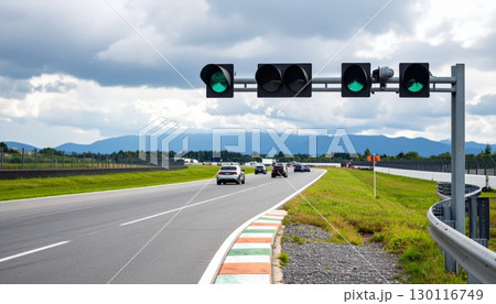 Summer journey on an empty freeway, with a car driving on an asphalt road stretching to the horizon under a green sky 130116749