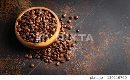 Closeup of roasted brown coffee beans overflowing from a white cup Closeup of roasted brown coffee beans overflowing from a white cup 130116760