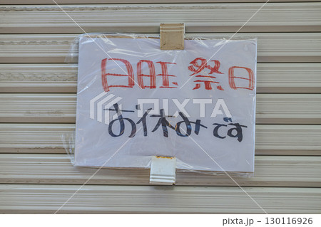 シャッターに貼られた日曜・祭日休業の手書きのお知らせ 休業日 張り紙 シャッターに貼られた日曜・祭日休業の手書きのお知らせ 休業日 張り紙 130116926