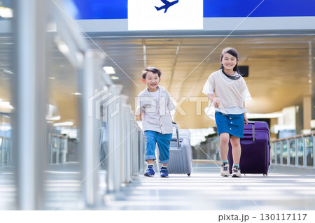 スーツケースをを引いて歩く子ども 130117117