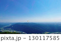 青空の高原からパラグライダーを眺める 130117585