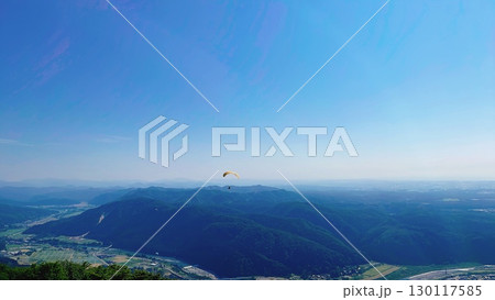 青空の高原からパラグライダーを眺める 青空の高原からパラグライダーを眺める 130117585