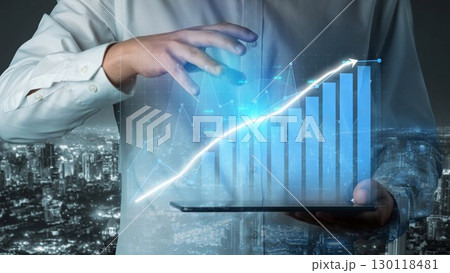 Businessman Analyzing Growth Charts with Digital Interface in Urban Skyline at Night, Representing Technology and Future Investments Copula 130118481