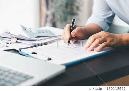 Business person with contract law and paper work for business finance, loan application form, contract real estate and insurance concept. signing contract, working on desk, business document Business person with contract law and paper work for business finance, loan application form, contract real estate and insurance concept. signing contract, working on desk, business document 130118622