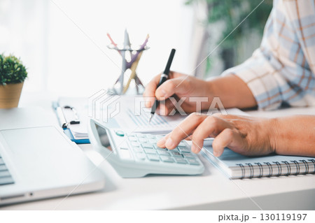 Accountant working on desk using calculator for calculate finance report in office. business finance, calculate tax by organizing financial documents, tracking income investment, accounting by hand. Accountant working on desk using calculator for calculate finance report in office. business finance, calculate tax by organizing financial documents, tracking income investment, accounting by hand. 130119197