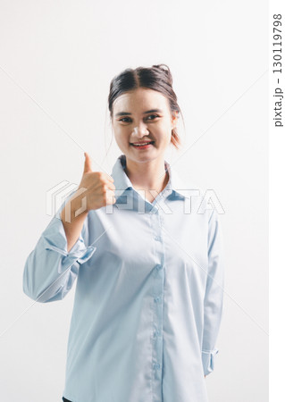Asian woman rejoicing, looking happy, champion, fist pump gesture, standing over white background. young woman had happy, positive expression on her face, highlighted by bright smile. 130119798