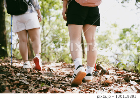 Hiking action on mountain grass trail path. Close up of female hiker shoe. adventurous lifestyle of hiker and backpack to travel and trek mountain, enjoy every walk and hike part of thrilling journey 130119893